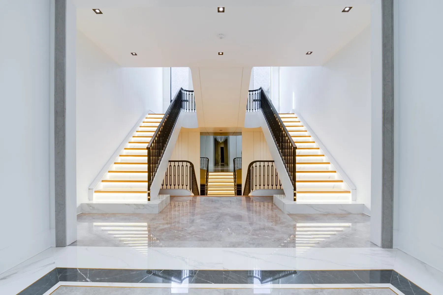 Symmetrical double staircase with backlit marble treads