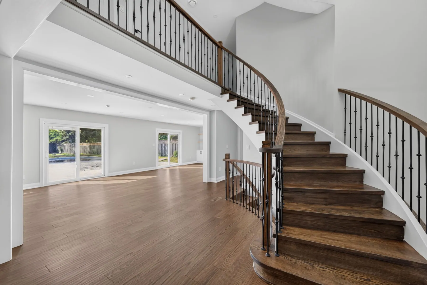 Curved oak staircase in an open two storey foyer