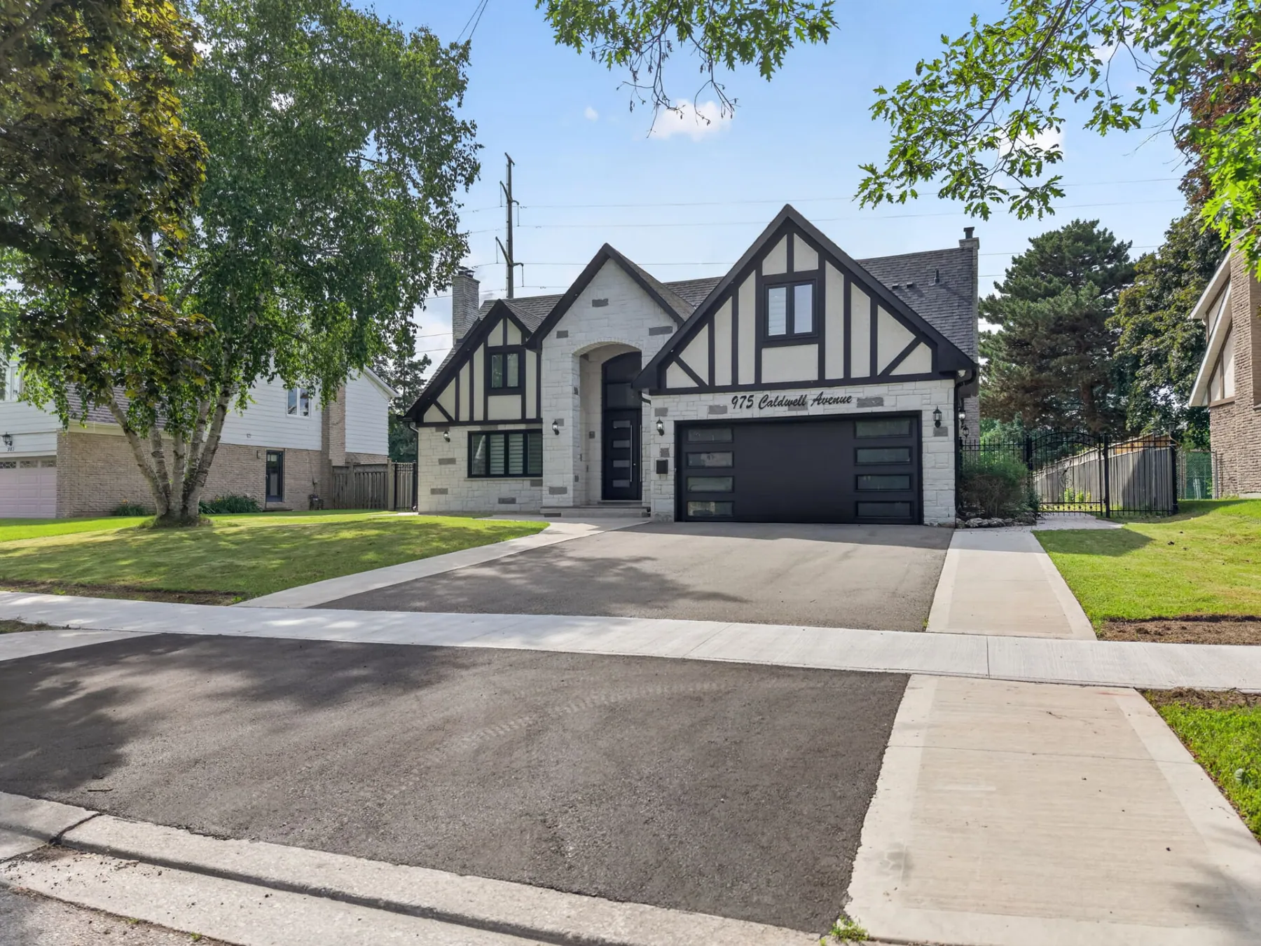 Street view of a renovated Tudor home with wide driveway
